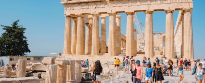 Visitors in the Acropolis of Athens, Greece, want to look closely the remains of the famous Parthenon, on a sunny summer day